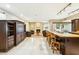 Well-lit kitchen area with a breakfast bar, overlooking a living room with a fireplace at 8187 E Del Caverna Dr, Scottsdale, AZ 85258