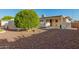 Serene backyard with well-kept landscaping, covered patio, and desert rock ground cover at 8338 E Milagro Ave, Mesa, AZ 85209