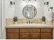 Stylish bathroom with a round mirror, decorative lights, and tile backsplash at 902 W Claremont St, Phoenix, AZ 85013
