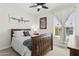 Neutral bedroom features a wooden bedframe, a window offering natural light, and unique wall art that enhance the room's character at 902 W Claremont St, Phoenix, AZ 85013