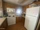 Functional kitchen featuring white appliances, wood cabinets and laminate floor at 1147 S Sioux Dr, Apache Junction, AZ 85119