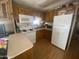 Functional kitchen featuring white appliances, wood cabinets and laminate floor at 1147 S Sioux Dr, Apache Junction, AZ 85119
