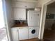Compact laundry area featuring stacked washer and dryer, white cabinets and laminate floor at 1147 S Sioux Dr, Apache Junction, AZ 85119