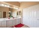 Bathroom features double sinks, a large mirror, and closet storage space for convenience at 11731 N 91St Pl, Scottsdale, AZ 85260