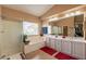 Bright bathroom with double sinks, a soaking tub, separate shower, and large vanity at 11731 N 91St Pl, Scottsdale, AZ 85260