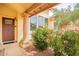 Inviting front porch entrance framed by flowering bushes, and a classic column at 11731 N 91St Pl, Scottsdale, AZ 85260