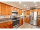 Modern kitchen with stainless steel appliances and wooden cabinetry at 11731 N 91St Pl, Scottsdale, AZ 85260