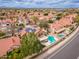 An aerial shot of a neighborhood displaying terracotta-roofed homes, some with solar panels and private pools at 13383 N 101St Way, Scottsdale, AZ 85260