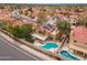 Aerial view of a home with solar panels, a pool, covered patio, and turf in a neighborhood with mountain views at 13383 N 101St Way, Scottsdale, AZ 85260