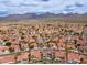 Wide aerial shot of a community with terracotta-roofed houses, palm trees, and mountain views in the distance at 13383 N 101St Way, Scottsdale, AZ 85260