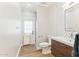 Modern bathroom with herring bone tile accent wall, wood vanity, and an exit door at 13383 N 101St Way, Scottsdale, AZ 85260