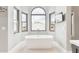 Bright bathroom featuring a soaking tub, arched window, and modern fixtures at 13383 N 101St Way, Scottsdale, AZ 85260