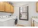 Laundry room with cabinets, white washer and dryer, and a window looking out at 13383 N 101St Way, Scottsdale, AZ 85260