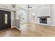 Spacious living room with a fireplace, wood floors, and large arched windows at 13383 N 101St Way, Scottsdale, AZ 85260