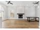Bright living room featuring a white brick fireplace, wood floors, and large windows at 13383 N 101St Way, Scottsdale, AZ 85260