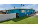 Inviting backyard showcasing the synthetic grass and the exterior blue paint of the house at 1340 E Golden Ln, Phoenix, AZ 85020