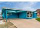 Unique blue home with a covered carport, spacious driveway, and modern architectural details at 1340 E Golden Ln, Phoenix, AZ 85020