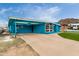 Quaint blue home with a carport, well-maintained lawn, and mature trees in a serene setting at 1340 E Golden Ln, Phoenix, AZ 85020