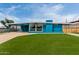 Bright blue home featuring a carport, large picture window, and a lush green lawn at 1340 E Golden Ln, Phoenix, AZ 85020