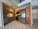 Well-equipped kitchen with stainless steel appliances, wooden cabinetry, and tile flooring at 15655 N 29Th St, Phoenix, AZ 85032