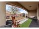 Inviting covered back patio features outdoor seating, artificial turf, and a spacious backyard, perfect for relaxing and entertaining at 16268 W Cortez St, Surprise, AZ 85379