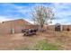 Wide backyard with a patio set, mature tree, and a block wall at 16268 W Cortez St, Surprise, AZ 85379