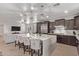 Open-concept kitchen with island seating, stainless appliances and seamless flow to the living area at 16268 W Cortez St, Surprise, AZ 85379