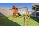 A backyard featuring a playset on artificial turf and a covered patio, creating a perfect outdoor space at 16462 W Rowel Rd, Surprise, AZ 85387