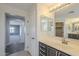 Bright bathroom with dual vanity, neutral walls, and doorway to the bathroom at 16462 W Rowel Rd, Surprise, AZ 85387