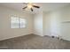 Spacious carpeted bedroom with ceiling fan and window with blinds at 16462 W Rowel Rd, Surprise, AZ 85387