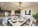 An open-concept kitchen flows into a dining area with seating for six beneath a modern chandelier at 16462 W Rowel Rd, Surprise, AZ 85387