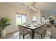 Dining room with modern table setting and chandelier with views out of the backyard at 16462 W Rowel Rd, Surprise, AZ 85387