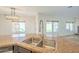 A granite countertop kitchen island offers a stainless-steel sink basin and views of an adjacent living space at 16462 W Rowel Rd, Surprise, AZ 85387