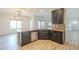 A kitchen island has dark cabinetry, a stainless-steel dishwasher and a stainless-steel sink basin at 16462 W Rowel Rd, Surprise, AZ 85387