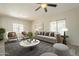 Bright living room featuring a ceiling fan, comfortable seating, and views of the landscape at 16462 W Rowel Rd, Surprise, AZ 85387