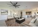 Open-concept living room with hardwood flooring, modern furnishings, and access to the kitchen at 16462 W Rowel Rd, Surprise, AZ 85387