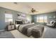 Main bedroom with a king bed, neutral colors, ceiling fan, and large windows with outdoor views at 16462 W Rowel Rd, Surprise, AZ 85387