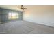 Bright main bedroom offering carpeted floors and views of the desert landscape at 16462 W Rowel Rd, Surprise, AZ 85387