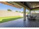 Covered patio area with artificial grass and a dining table, perfect for outdoor living at 16462 W Rowel Rd, Surprise, AZ 85387
