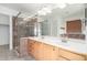 Bathroom featuring double sinks, granite countertop, glass shower, and large mirror at 1701 E Yukon Dr, Phoenix, AZ 85024