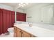 Bright bathroom featuring a red shower curtain, mirror, and a sink with a light wood cabinet at 1701 E Yukon Dr, Phoenix, AZ 85024
