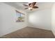 Bedroom featuring neutral carpet, ceiling fan, and a window with a view at 1701 E Yukon Dr, Phoenix, AZ 85024
