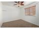 Carpeted bedroom with a ceiling fan and large window, providing ample natural light at 1701 E Yukon Dr, Phoenix, AZ 85024