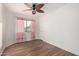 Bedroom featuring wood flooring, a ceiling fan, and a window with curtains at 1701 E Yukon Dr, Phoenix, AZ 85024