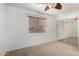 Bedroom with neutral carpet, mirrored closet, and window with wood blinds at 1701 E Yukon Dr, Phoenix, AZ 85024