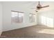 Bright bedroom featuring neutral carpet, a ceiling fan, and natural light from two windows at 1701 E Yukon Dr, Phoenix, AZ 85024