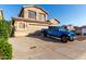 A two-story home with a two-car garage, desert landscaping, and a blue Jeep parked outside at 1701 E Yukon Dr, Phoenix, AZ 85024