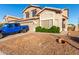 Exterior view of a well-kept home with a two-car garage, tidy landscaping, and desert rock in the front yard at 1701 E Yukon Dr, Phoenix, AZ 85024