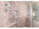Close-up of shower featuring marble walls, built-in shelving, and adjustable shower head at 1701 E Yukon Dr, Phoenix, AZ 85024