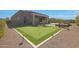 Expansive backyard with putting green, desert landscaping, and modern home architecture at 17756 E Colt Dr, Queen Creek, AZ 85142
